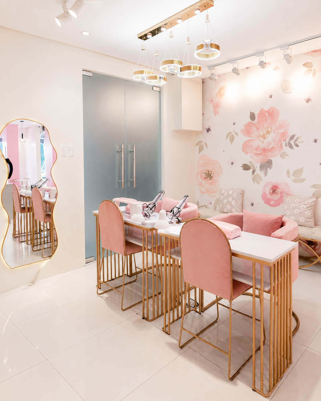 Bright manicure workspace prepared with pink chairs, tables, and professional nail tools.